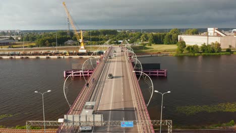 Aerial-shot-backwards-over-a-bridge-intersecting-with-a-roundabout