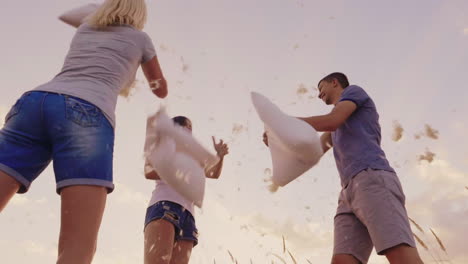 pillow fight a group of friends have fun - beats each other with pillows feathers fly slow motion vi