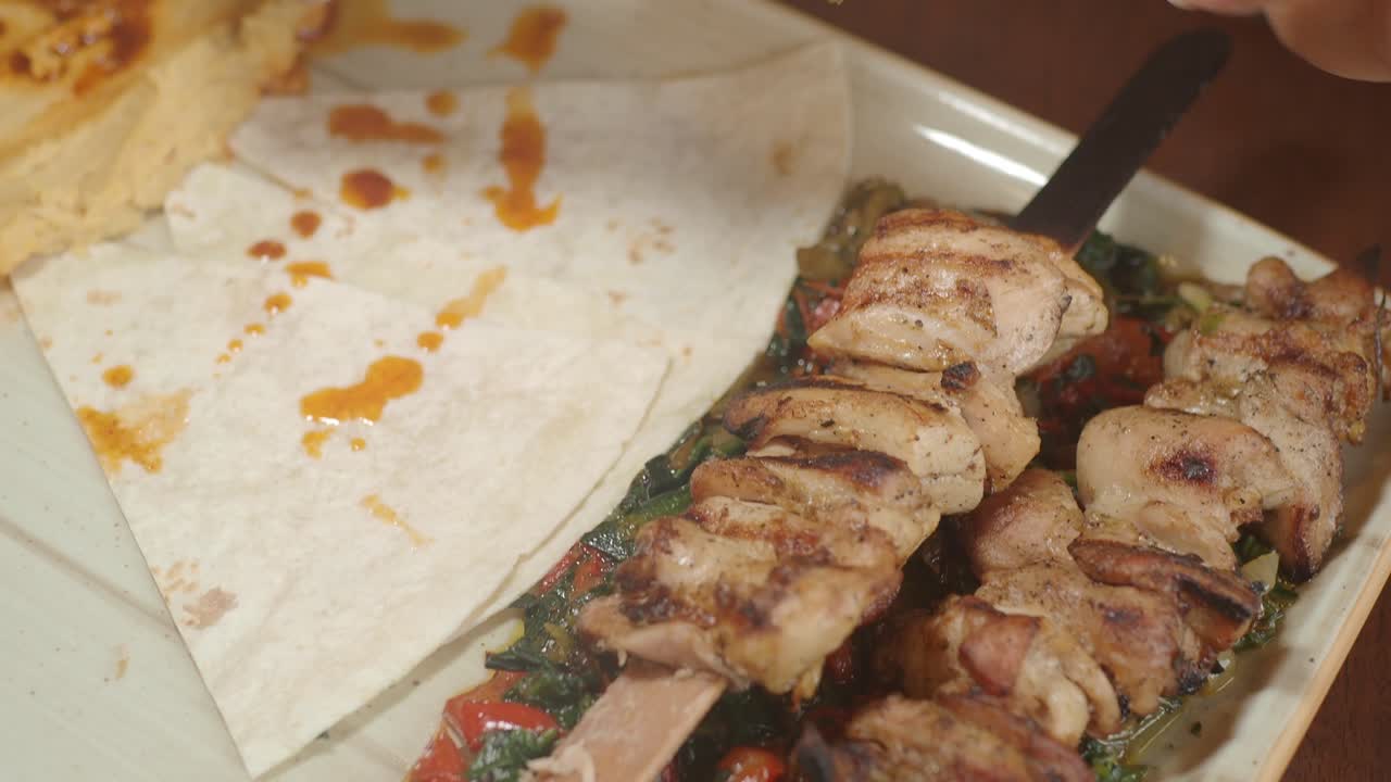 Eating Grilled Chicken and Meat Skewers with Pita