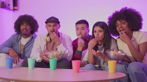 friends enjoying a movie night with snacks on the couch