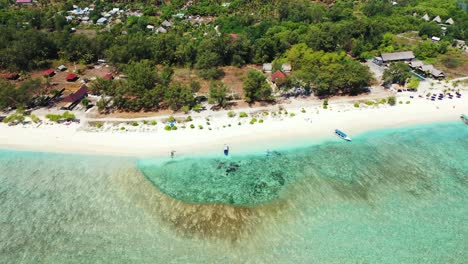 Exotic-beach-with-white-sand-washed-by-crystal-emerald-water-of-turquoise-lagoon-with-coral-reefs-in-Bali