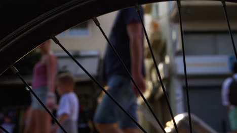 People-in-the-street-View-against-sun-flare-through-the-bike-wheel