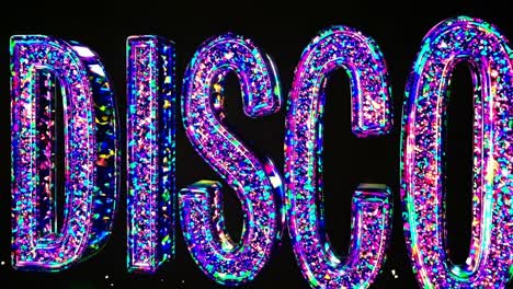 colorful, glittering disco letters shining brightly against a black background, creating a vibrant and energetic atmosphere perfect for music, dance, and nightlife themes