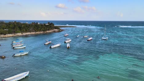 drone shot of the akumal coast with boats floating