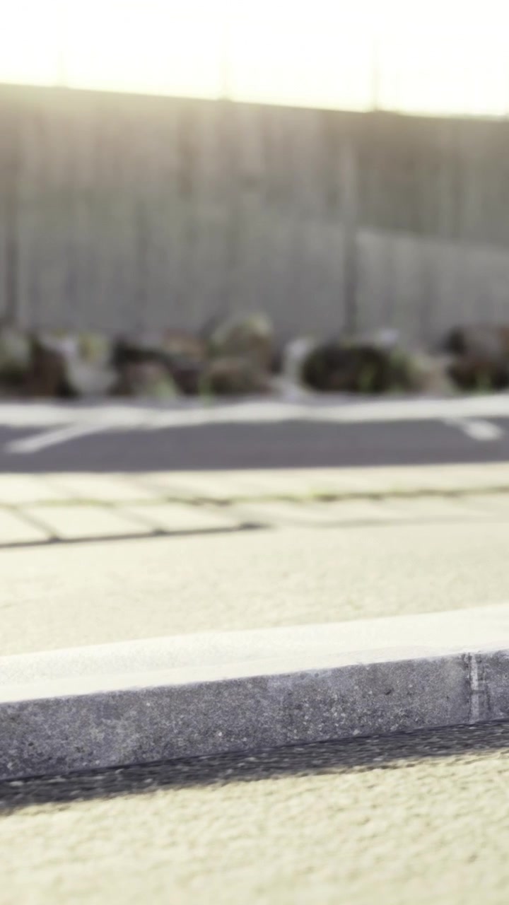 Roadside view with a close focus on pavement and distant wall in the background