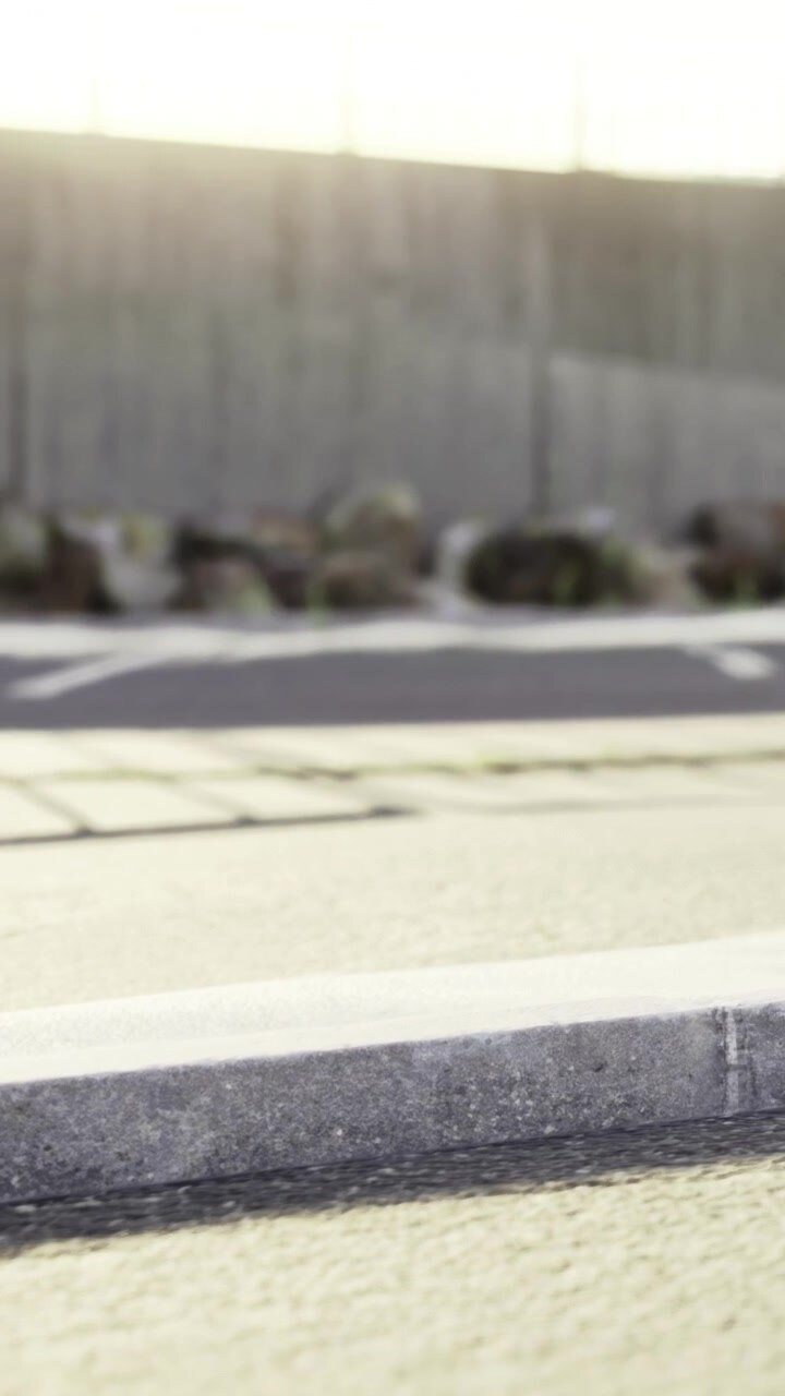 Roadside view with a close focus on pavement and distant wall in the background