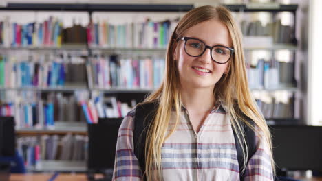 portrait of female student standing in college library