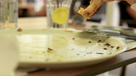 tomando el último pedazo de pizza de un plato blanco en un restaurante italiano