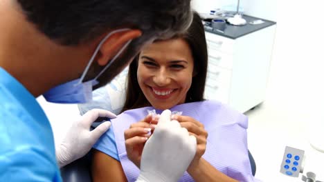 Dentista-Ayudando-A-Una-Paciente-A-Usar-Aparatos-Ortopédicos