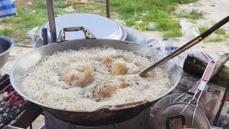 deep frying food at a street food stall