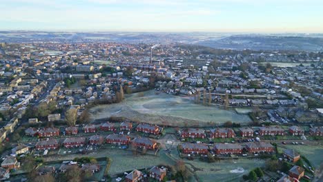 aerial footage of a mist covered urban town of dewsbury moor council estate in yorkshire uk, showing busy roads traffic and red brick houses