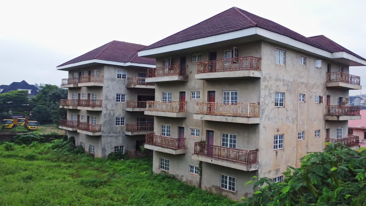 Beautiful aerial of the facade of a large and abandoned apartment building in Nigeria, Africa on a cloudy day