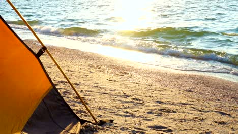 camping  tent on a sandy sea beach at the sunrise time