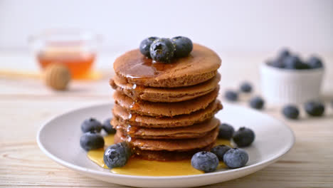 chocolate pancake stack with blueberry and honey on plate