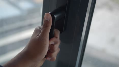 a close-up of a person's hand opening a window