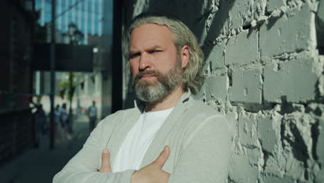 man with arms crossed in an alley