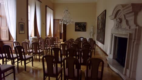 Castle-room-in-baroque-style-equipped-with-chairs-and-period-paintings