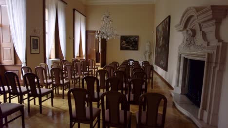 castle room in baroque style equipped with chairs and period paintings