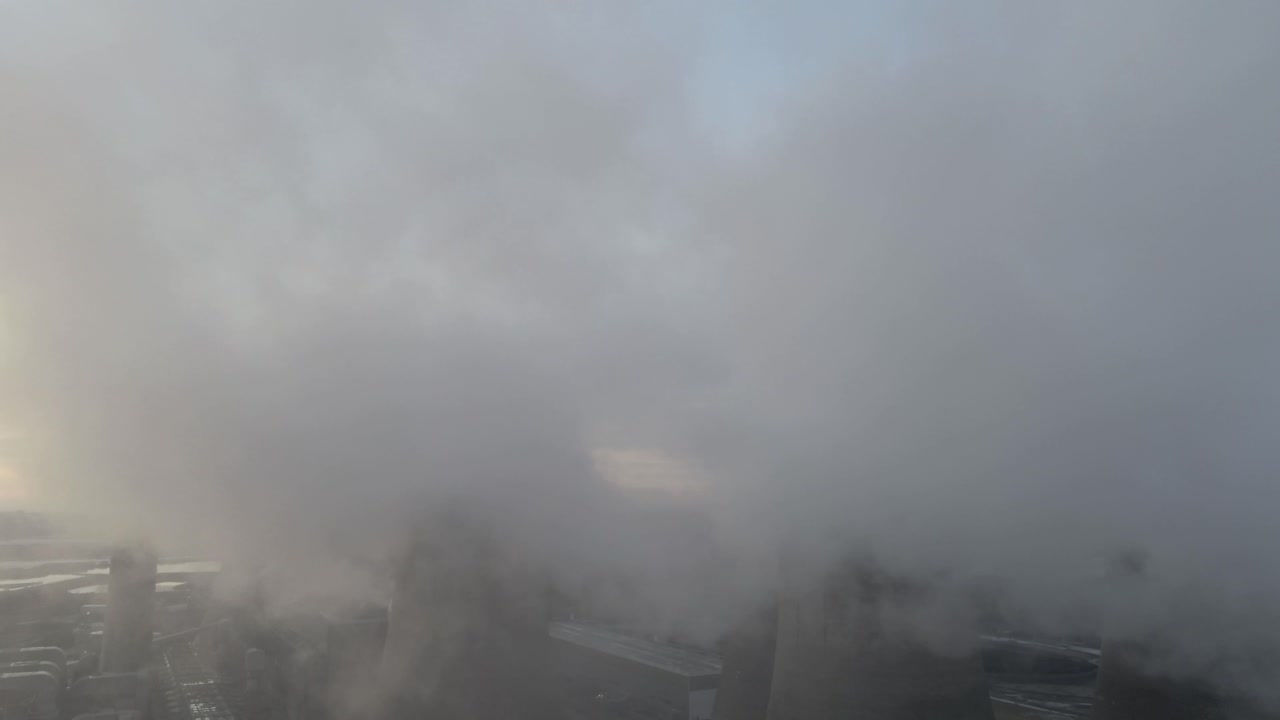 일출 시 연기 증기 배출이 내려다보이는 영국 발전소 냉각탑의 조감도