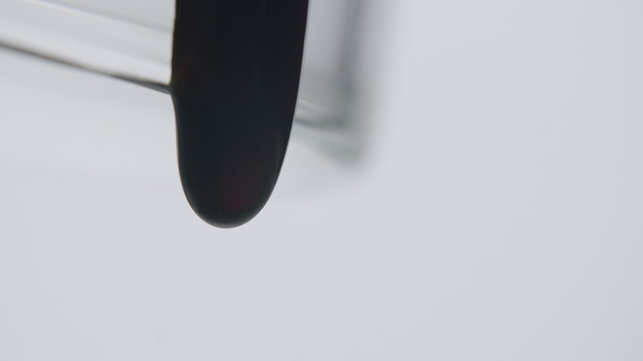 유리에서 떨어지는 깊은 검은 액체