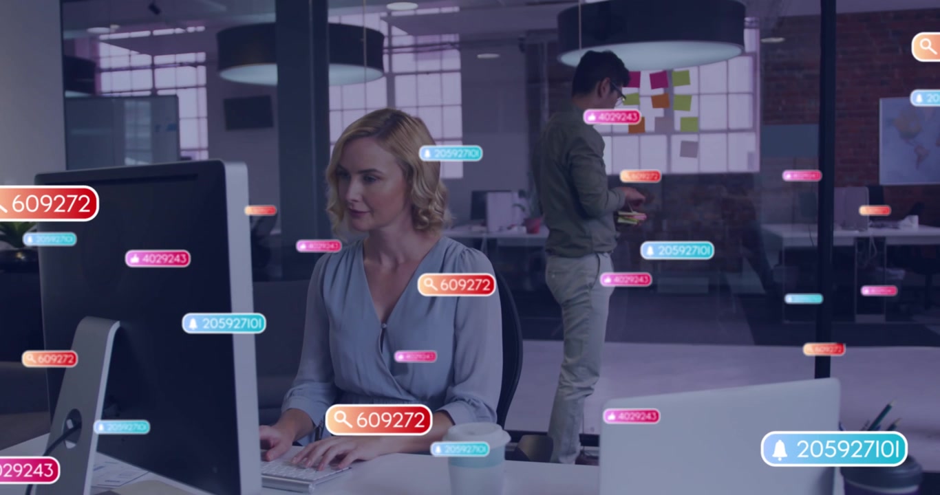 Animation of social media icons against caucasian woman using laptop at office