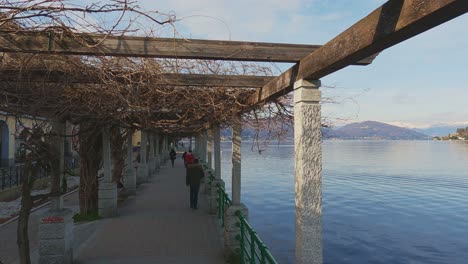 first-person view walking under porch along arona lakeside, italy