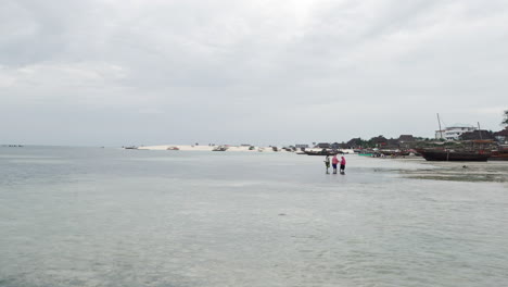playa de arena, océano y barcos de madera en zanzíbar en un día nublado, tanzania
