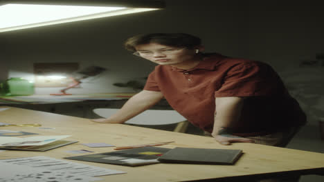 a young designer standing at a desk in a creative workspace