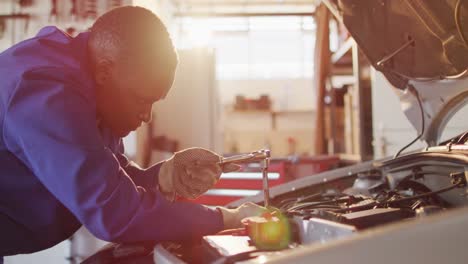 video of african american female car mechanic repairing car
