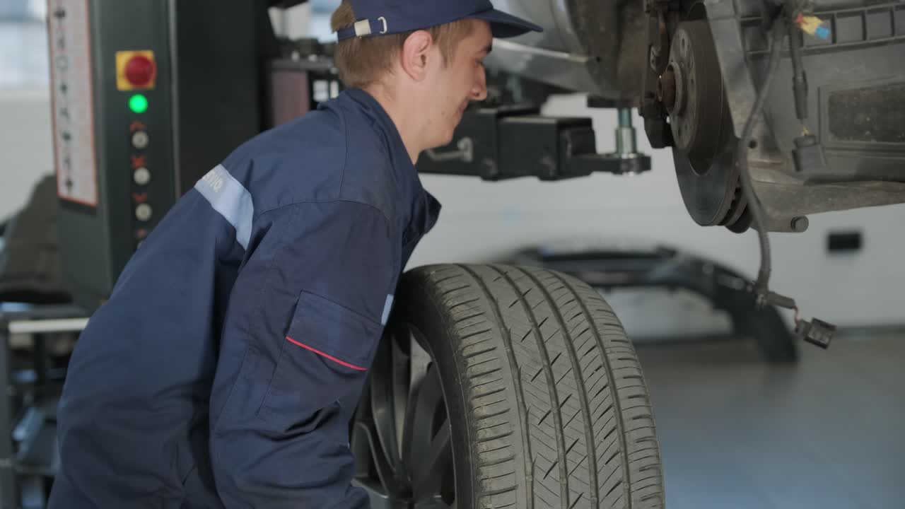 mecánico cambiando la rueda del coche con llave inglesa de impacto