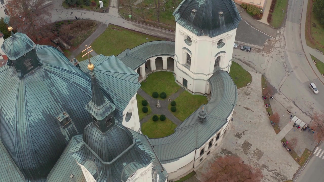 Drone flyr over hovedkirken Virge Nmarie i den lille byen Křtiny nær Brno i Tsjekkia, viser innvendig hage fra oven og bygningen ved siden av.