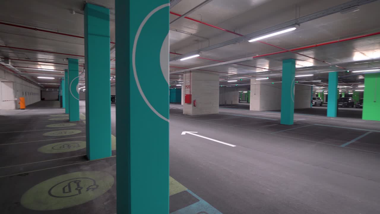 panorámica de derecha a izquierda, puntos de carga de vehículos eléctricos vacíos en un estacionamiento subterráneo