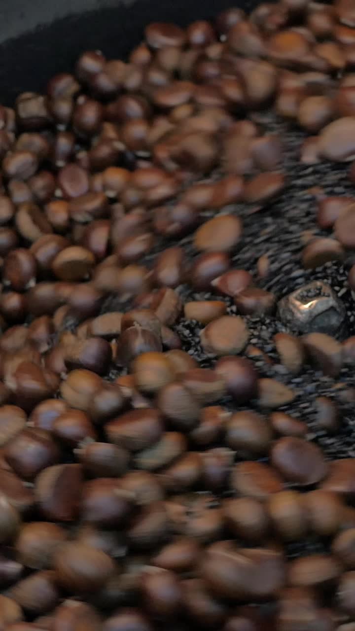 Castagne che arrostiscono e ruotano in una macchina commerciale