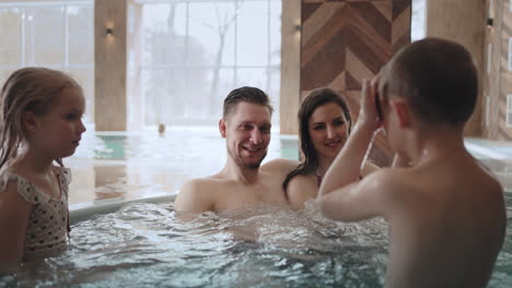 hydrotherapy-in-thermal-bath-family-with-kids-is-relaxing-in-dad-mom-daughter-and-son