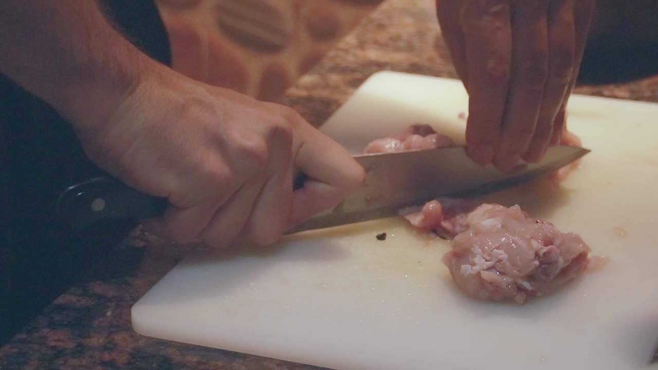 Close up to chopping leftover bones from a deboned chicken to be used for broth to reduce waste at home for a more sustainable lifestyle