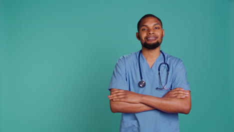 portrait of jolly male caregiver standing with arms folded
