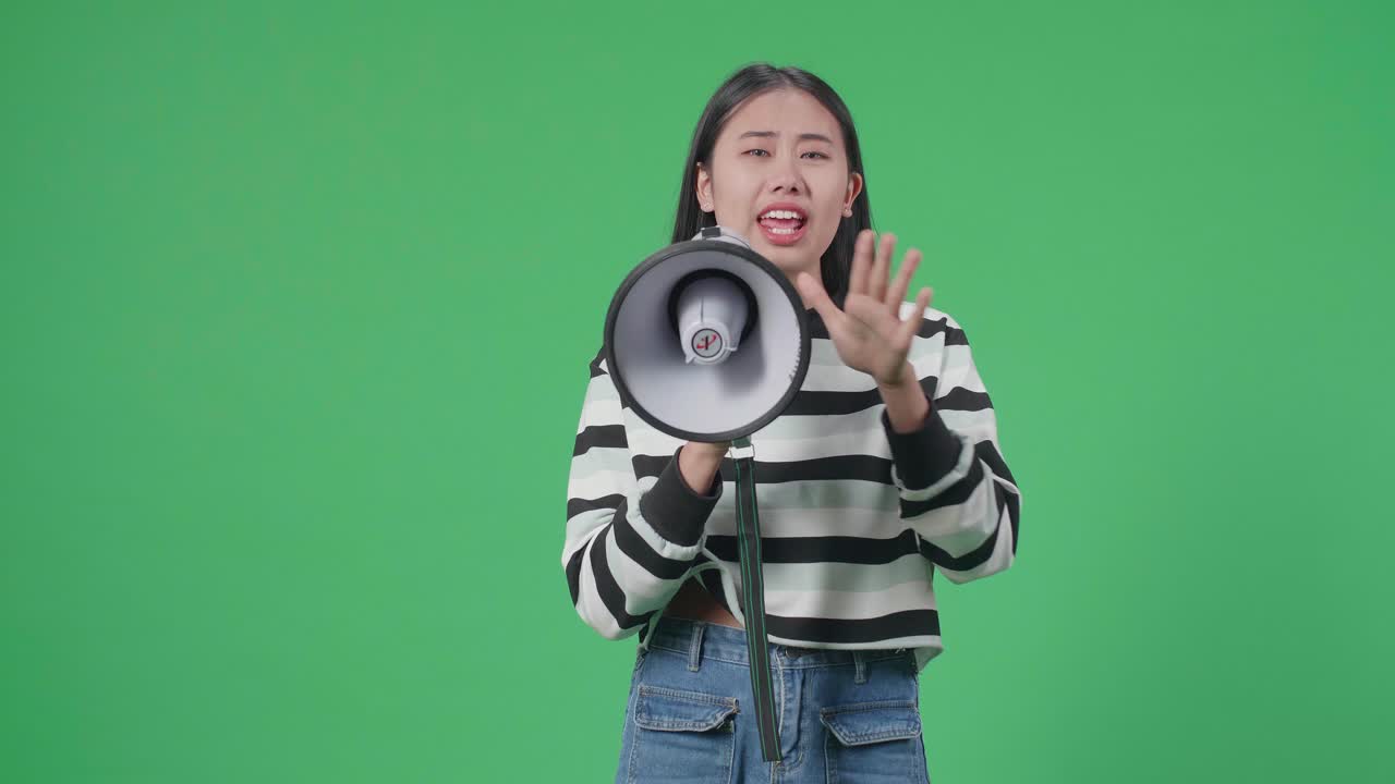 Asian Woman Speaking On Megaphone In The Green Screen Studio