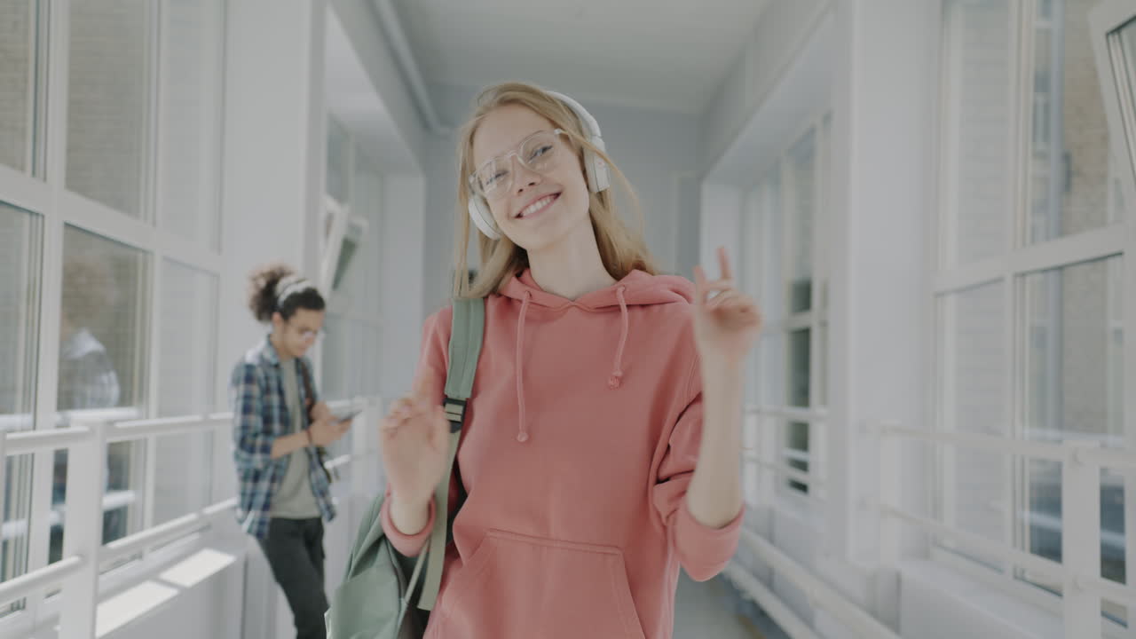 Девочка-подросток слушает музыку в школьном коридоре