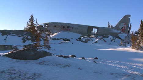 a crashed plane sits on frozen tundra in the arctic