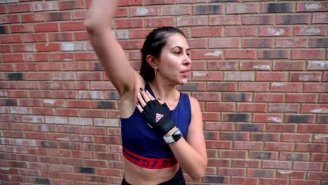 sporty young adult hispanic female rotating arms warming up strength exercising