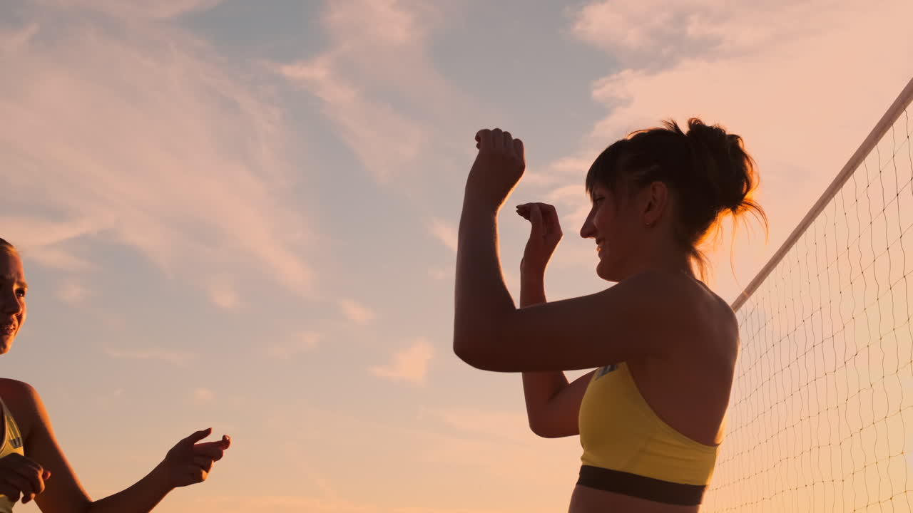 dos chicas jóvenes dando los cinco después del partido de voleibol