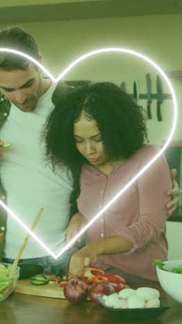 animation of heart icon over happy diverse couple cooking