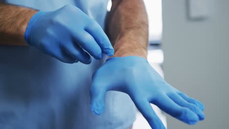 caucasian male doctor putting his protective gloves on