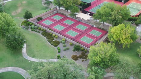 a drone glides towards a set of stunning tennis courts and pans down to reveal a topdown view