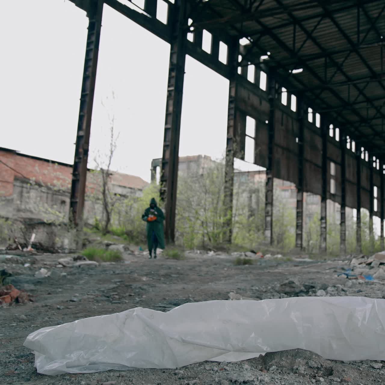 Abandoned building with garbage inside. Scientist in protective uniform in destroyed building. Biological attack