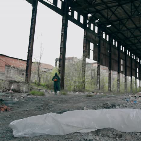abandoned building with garbage inside. scientist in protective uniform in destroyed building. biological attack