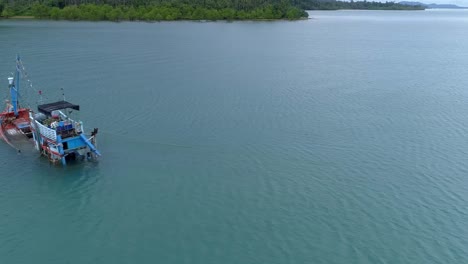 halb versunkenes fischerboot am ufer einer einsamen insel seitlich drohnenschuss abgeschnitten