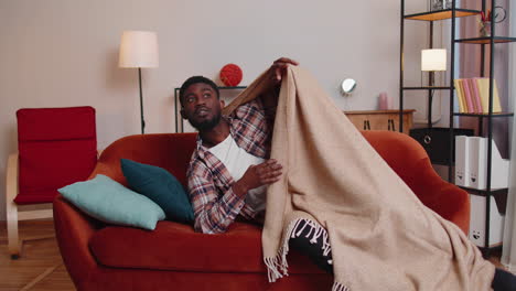 Terrified-scared-african-american-young-man-wakes-up-from-stress-nightmare-in-bedroom-at-home-sofa