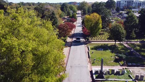 Aerial-view-of-a-white-pickup-truck-driving-through-the-historic-Oakland-Cemetery-in-Atlanta,-Georgia