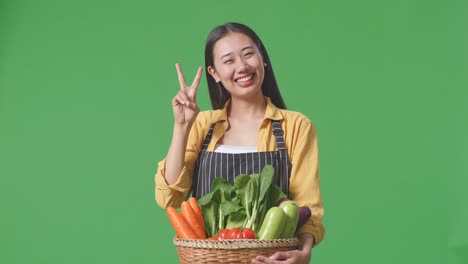 smiling woman farmer holding basket of vegetables